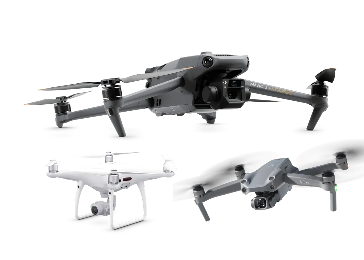 Tres drones DJI sobre un fondo liso: un cuadricóptero empresarial grande con cámara en gimbal, un cuadricóptero blanco de tipo Phantom y un cuadricóptero gris plegable